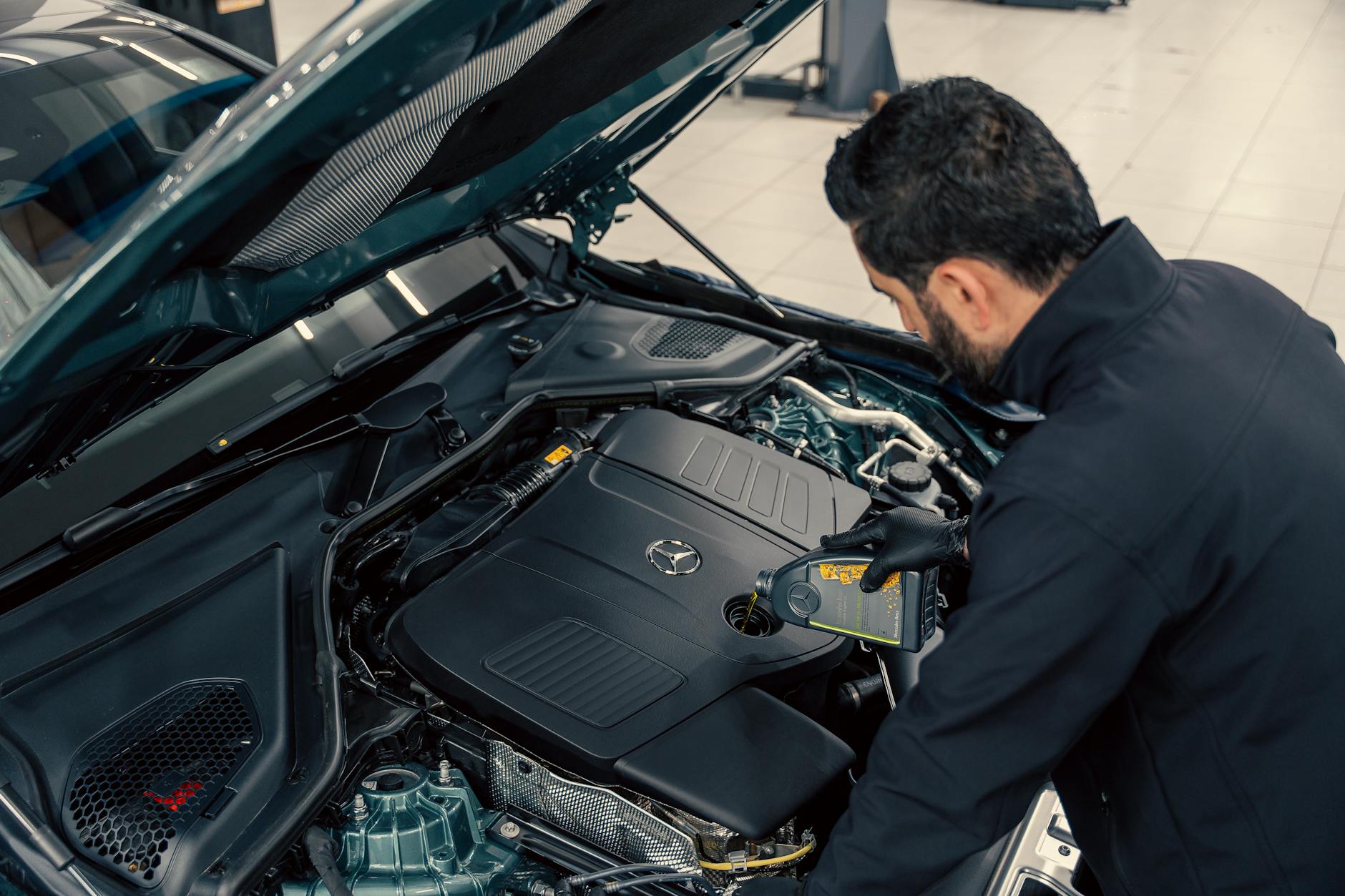 technician performing a routine maintenance check on a Mercedes Benz S Class Convertible